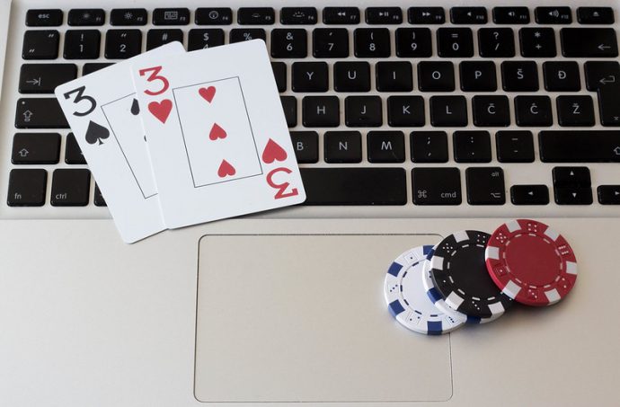 laptop keyboard, poker chips and cards